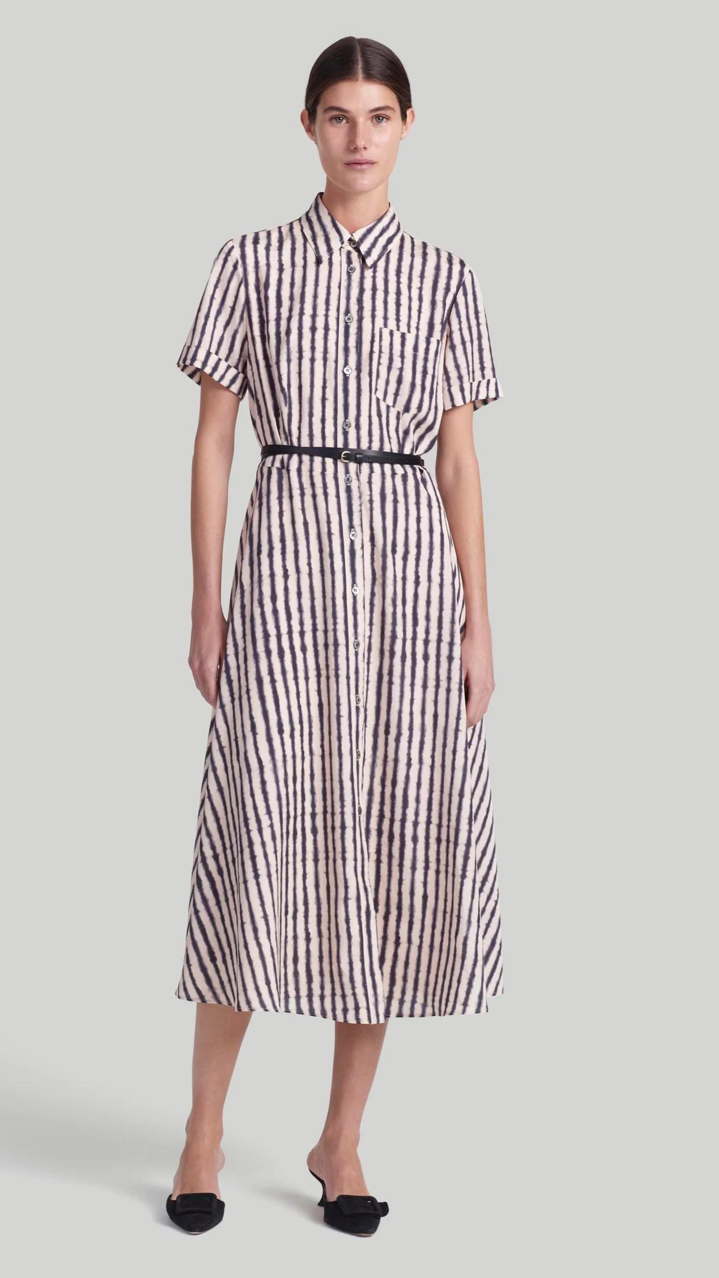 Altuzarra Kiera Dress The 'Kiera' dress is designed with a small point collar, short sleeves and a flattering A-line skirt. It is detailed with a slim leather waist belt and features a black and white stripe pattern and a front breast pocket. Shown on model facing front.