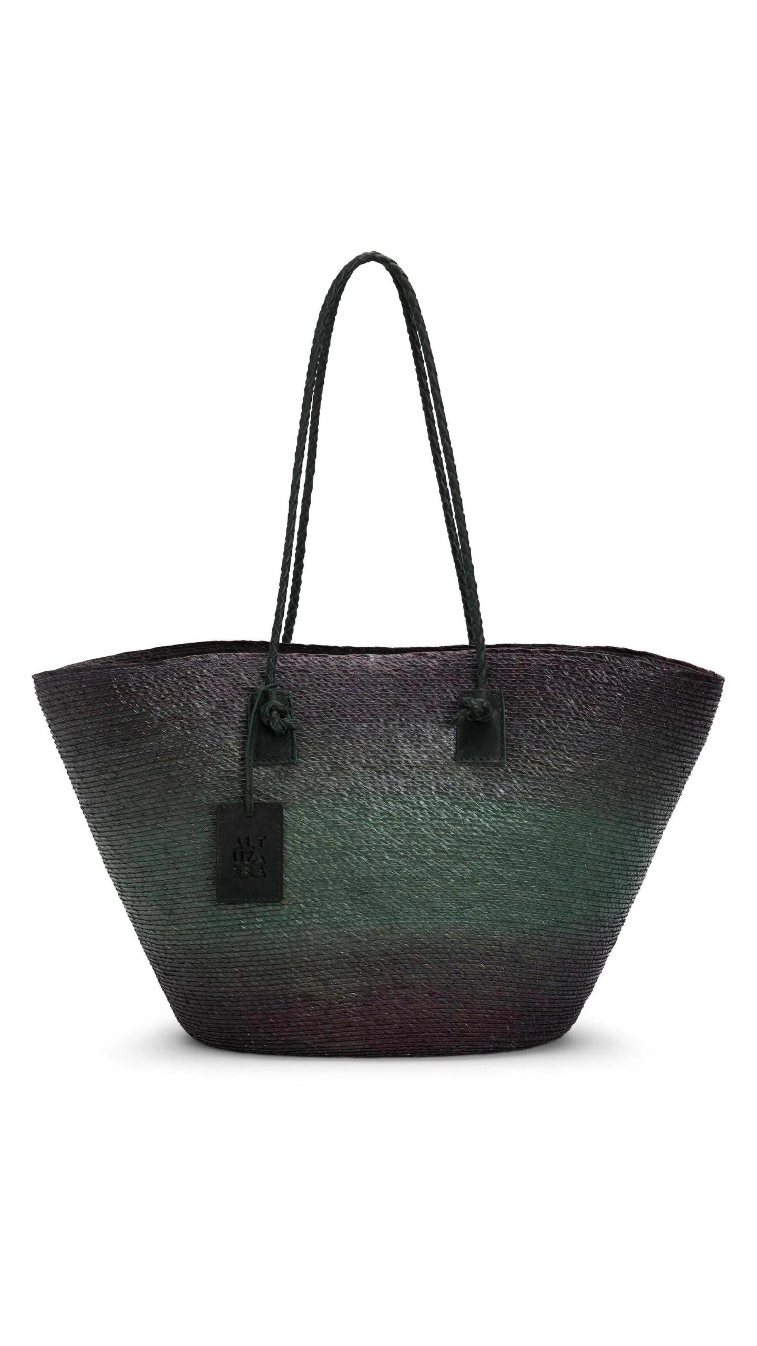 Altruzarra Large Watermill Bag in Campo. A summer raffia tote bag handmade in Mexico. It has a ombre tone with black and green. With a braided leather strap and black leather details. This photo shows the bag from the front view. Available at experience 27 in Madrid Spain. 