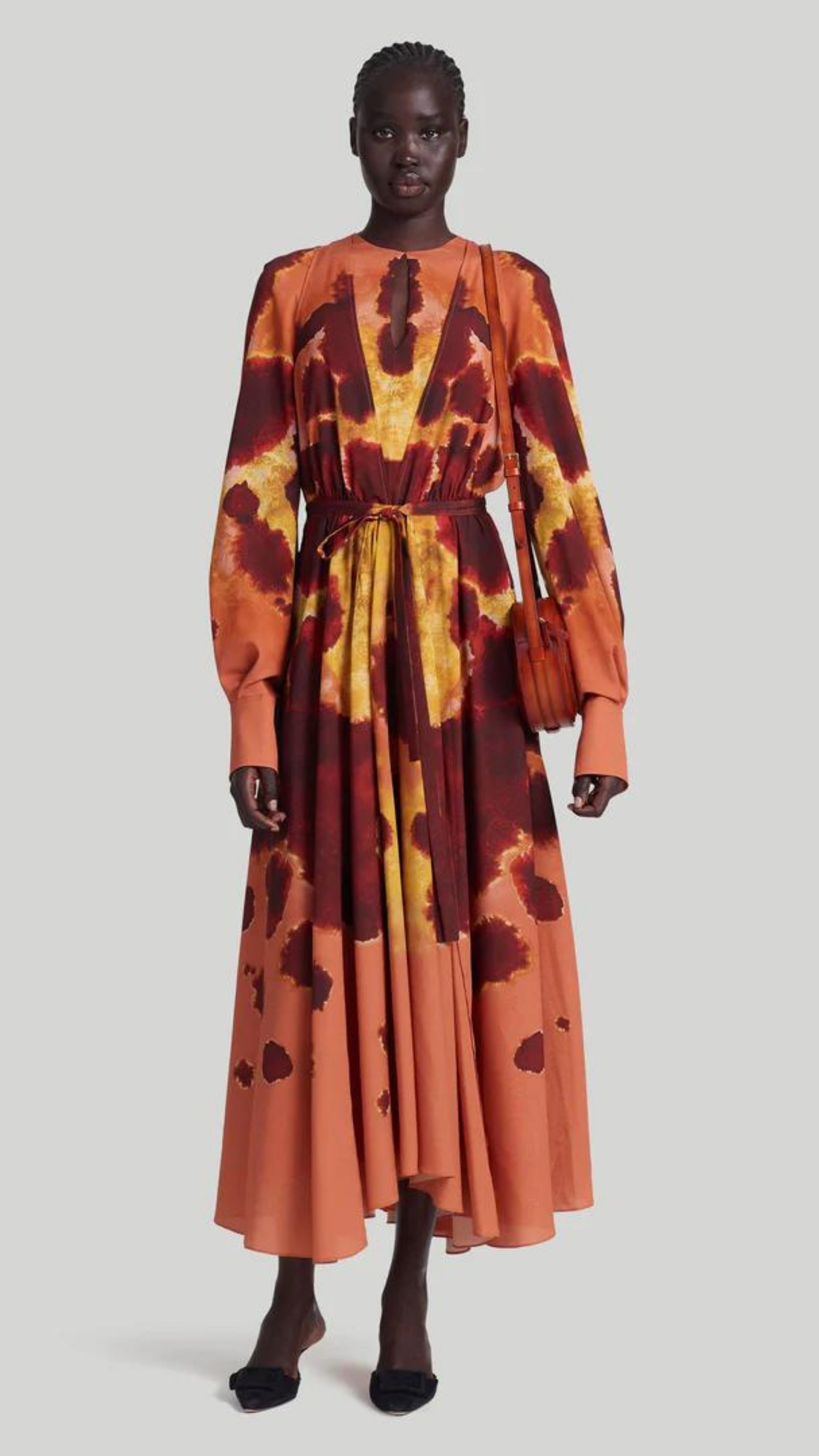 Altuzarra Peirene Dress. The Peirene midi dress has a relaxed silhouette with a tie at the waist. The keyhole neck can be styled closed or open, creating a v-neck look. Made in beautiful peach, cranberry, and yellow dyed pattern. Shown on model facing front