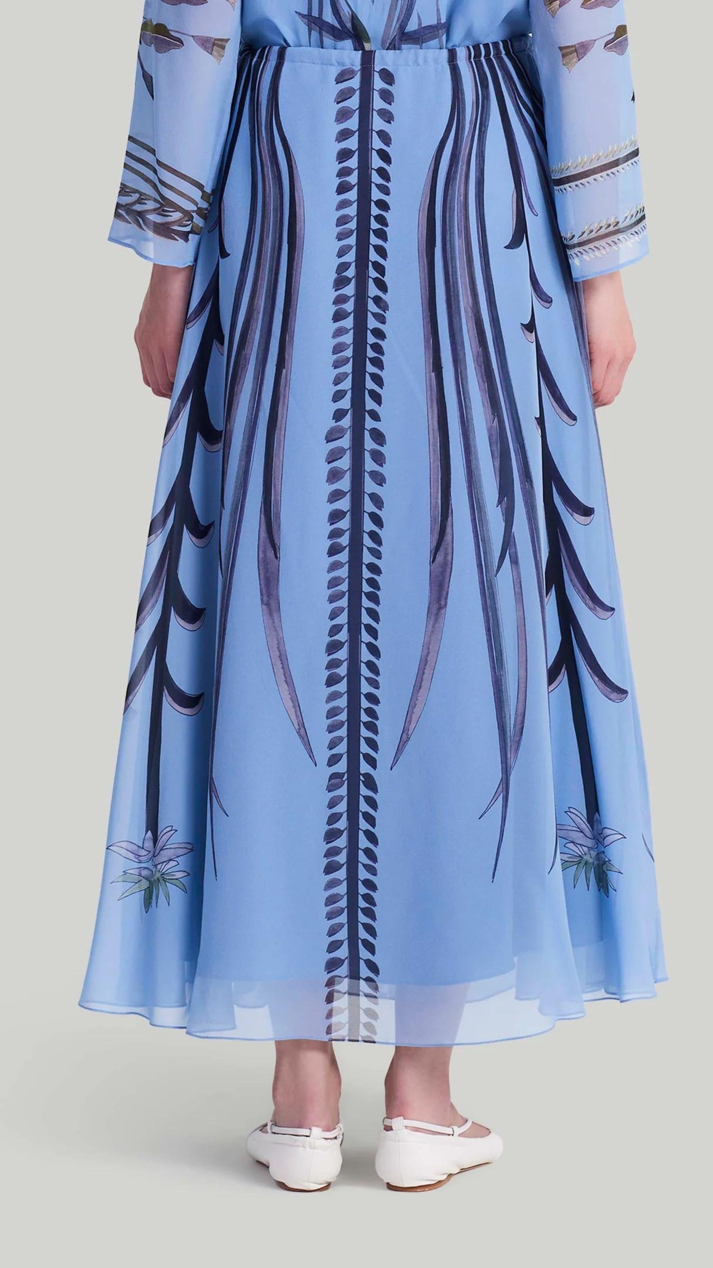 Altuzarra Roxana Skirt. Sky blue, navy blue and violet highlight. Hand painted skirt with adjustable tied at the waist. Midi length. Natural pattern. Shown on model facing back.