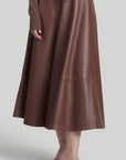 Altuzarra Varda Skirt Made from soft, subtle brown lamb leather, it has an A-line skirt. Midi-length SS24 runway piece. The skirt hem falls to just below the knee. Shown on model facing front.