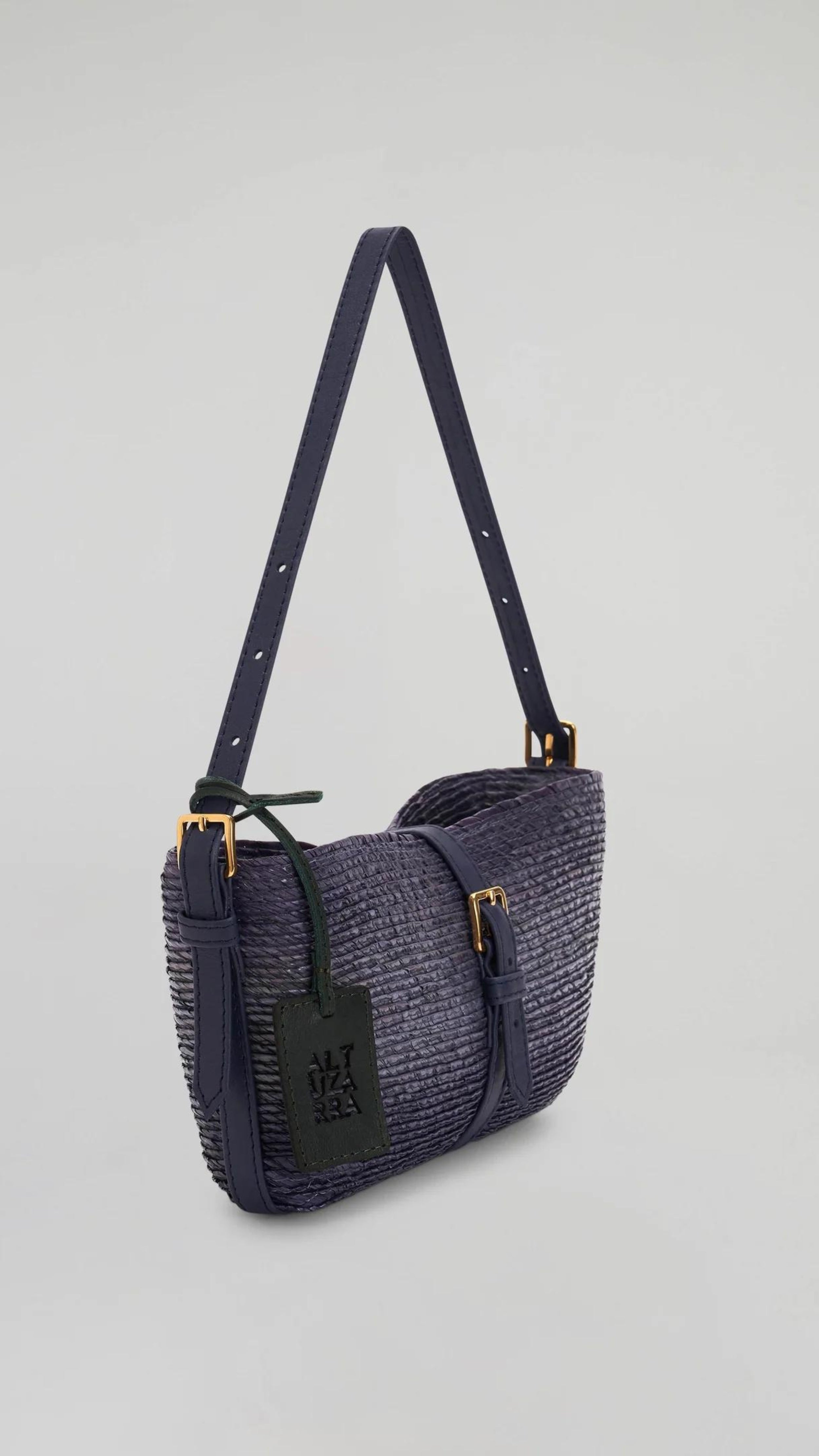 Altruzarra WATERMILL SHOULDER BAG in Murex. Raffia summer purse in deep blue tones and navy blue leather detailing and gold hardware. Shown from the front side. Available at Experience 27 Madrid Spain.
