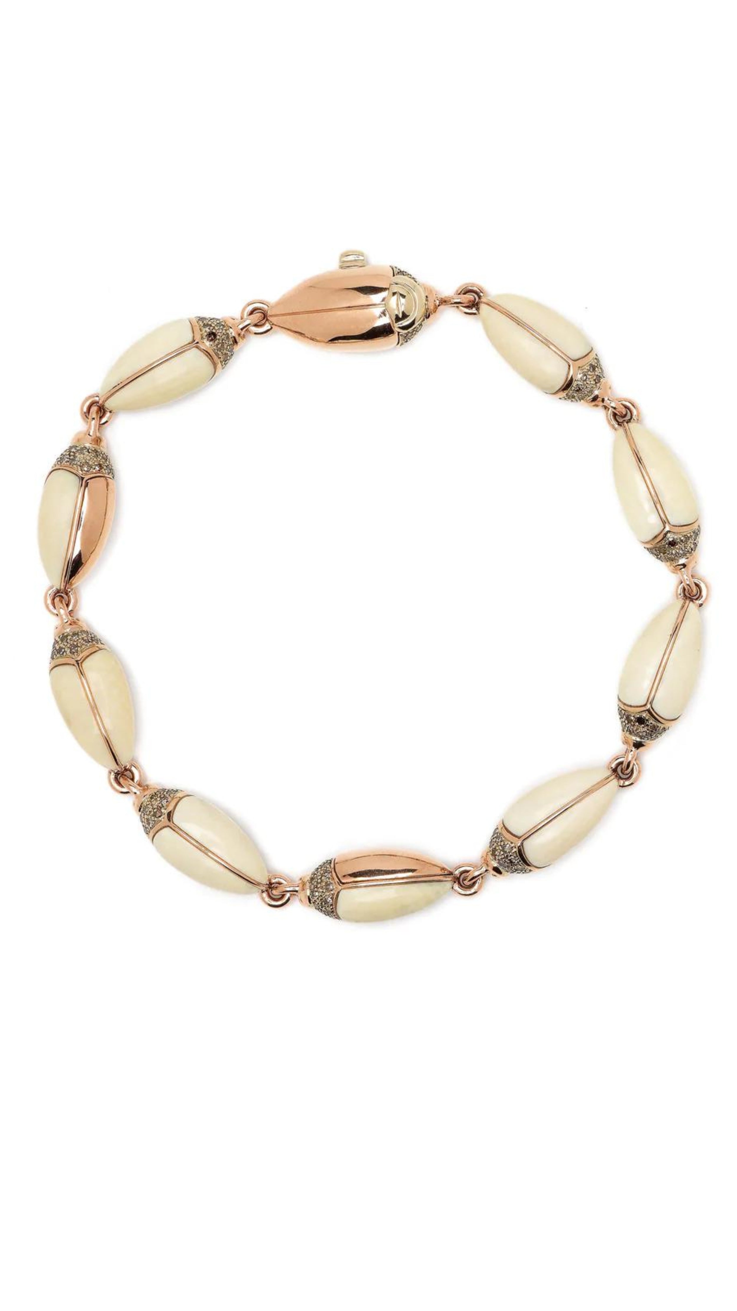 Bibi van der Velden Winter Mammoth Scarab Bracelet is made from creamy tones of polished and carved mammoth tusk, 18k yellow gold, 925 sterling silver, and brown diamonds. Individual scarabs are linked together. Shown from above.