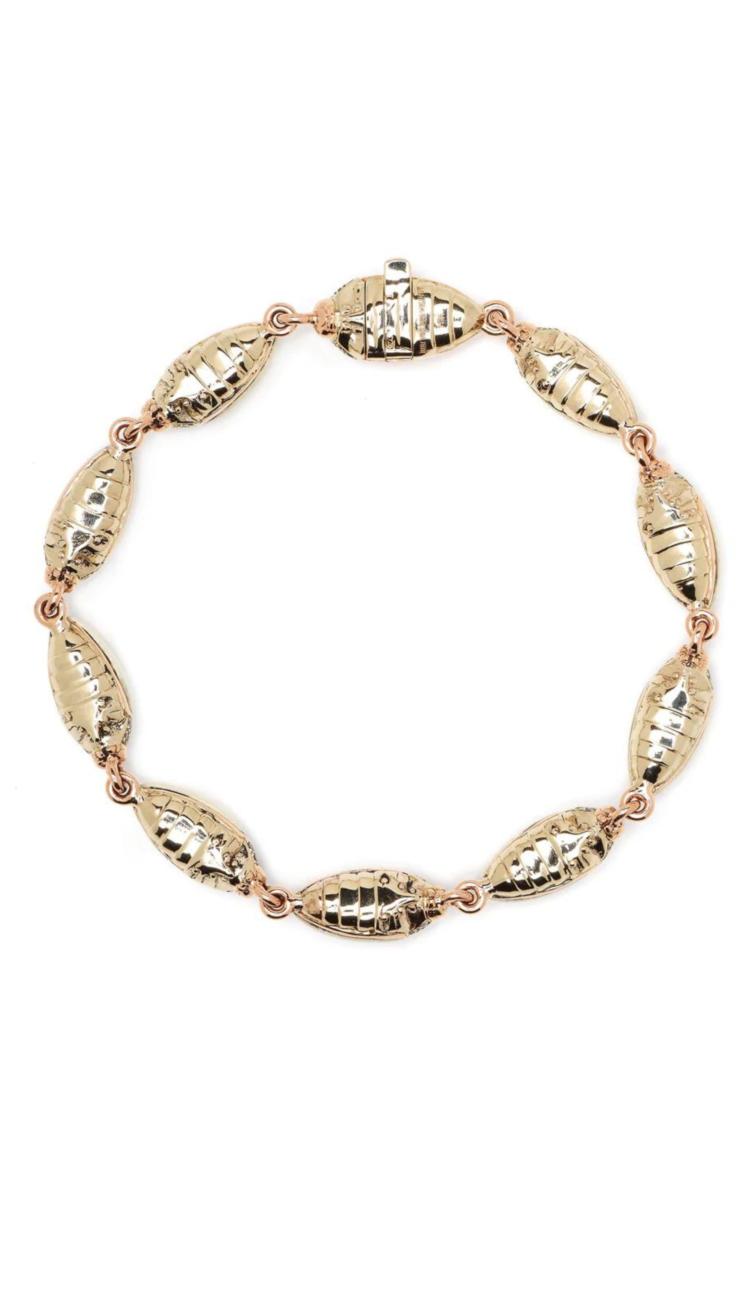 Winter Mammoth Scarab Bracelet is made from creamy tones of polished and carved mammoth tusk, 18k yellow gold, 925 sterling silver, and brown diamonds. Individual scarabs are linked together. Shown from the back.