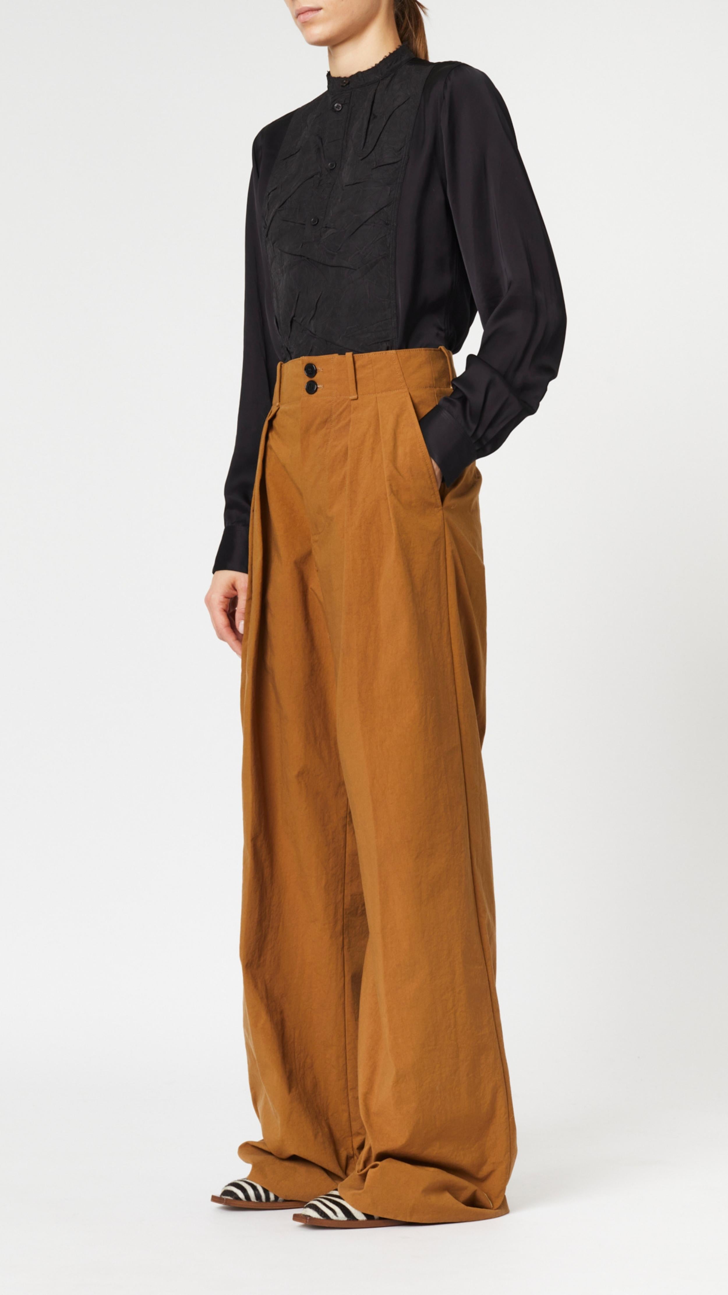 Plan C Camel Boyfriend Trouser in Nylon. Slightly oversized style with high waist and double button front closure. Pleated front panels and loose fit. Photo shown on model facing side with hand in pocket..