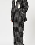 Plan C Checked Black Blazer. Modern suit jacket option in an oversized fit in lightweight wool. Classic black and white check pattern. Shown on model open and facing to the side.