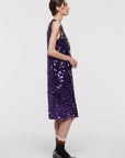 Plan C Color Block Sequin Dress. Sleeveless racer back style midi length dress in purple and lime green. Trimmed in black at the neckline and arms. The green sequins form a v shape in the front. Shown on model facing side.