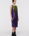 Plan C Color Block Sequin Dress. Sleeveless racer back style midi length dress in purple and lime green. Trimmed in black at the neckline and arms. The green sequins form a v shape in the front. Shown on model facing forward.