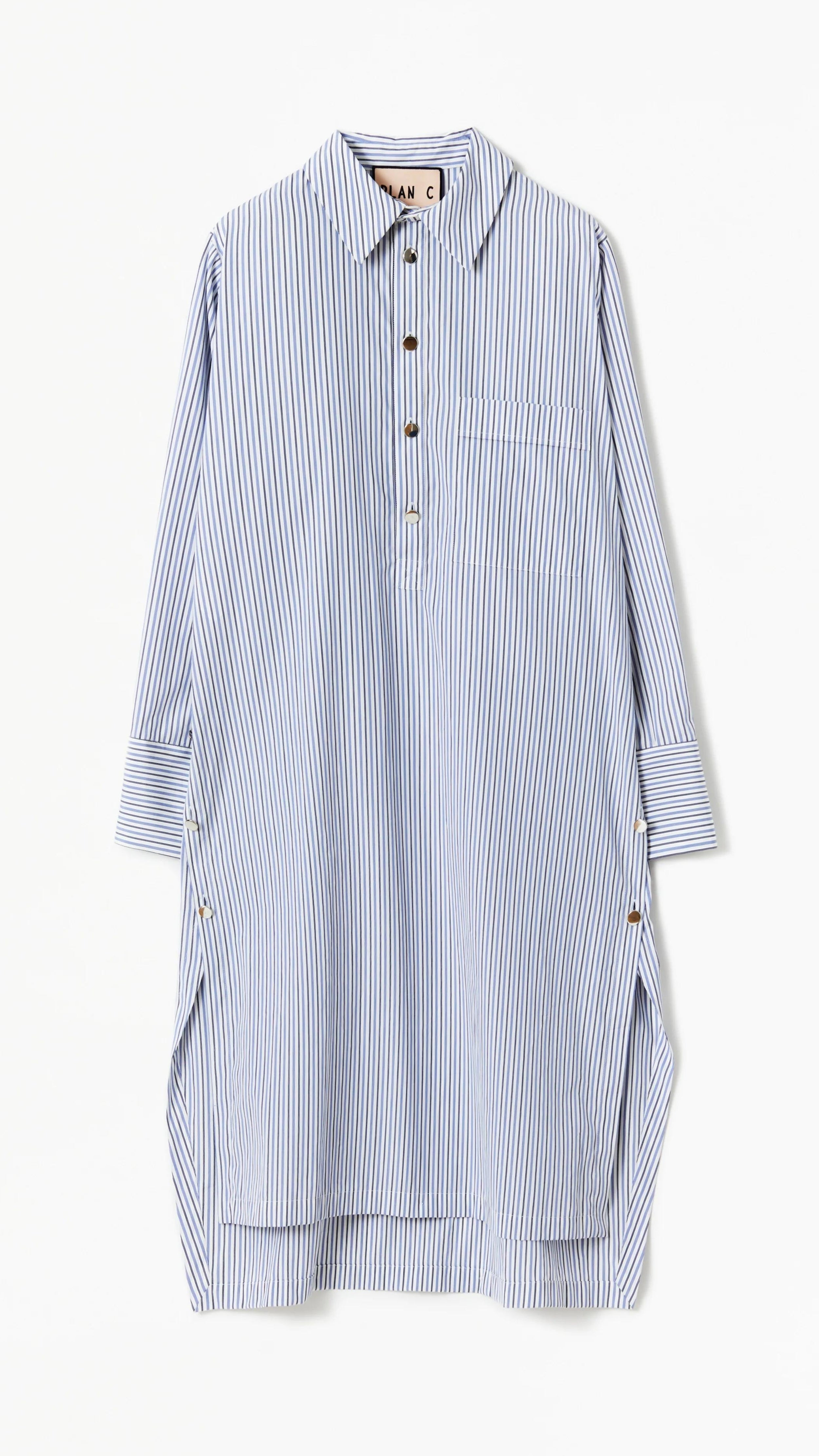 Plan C Striped Cotton Poplin Shirt Dress Classic yet modern shirt dress made from soft cotton poplin in pale blue and white stripes. It has three silver buttons, a collared neckline, long cuffs, and a breast pocket. It's designed with a relaxed fit and side pockets. Product flat photo of the front.