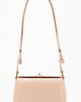 Plan C The Mini Folded Bag in Sand Pink. Luxury handbag crafted in Italy from soft calfskin with an adjustable leather shoulder strap. This purse has a gold-toned turnstile top closure and offers three compartments, one flat zipped and one snap buttoned pocket. Photo shown from the front view with the adjustable strap.