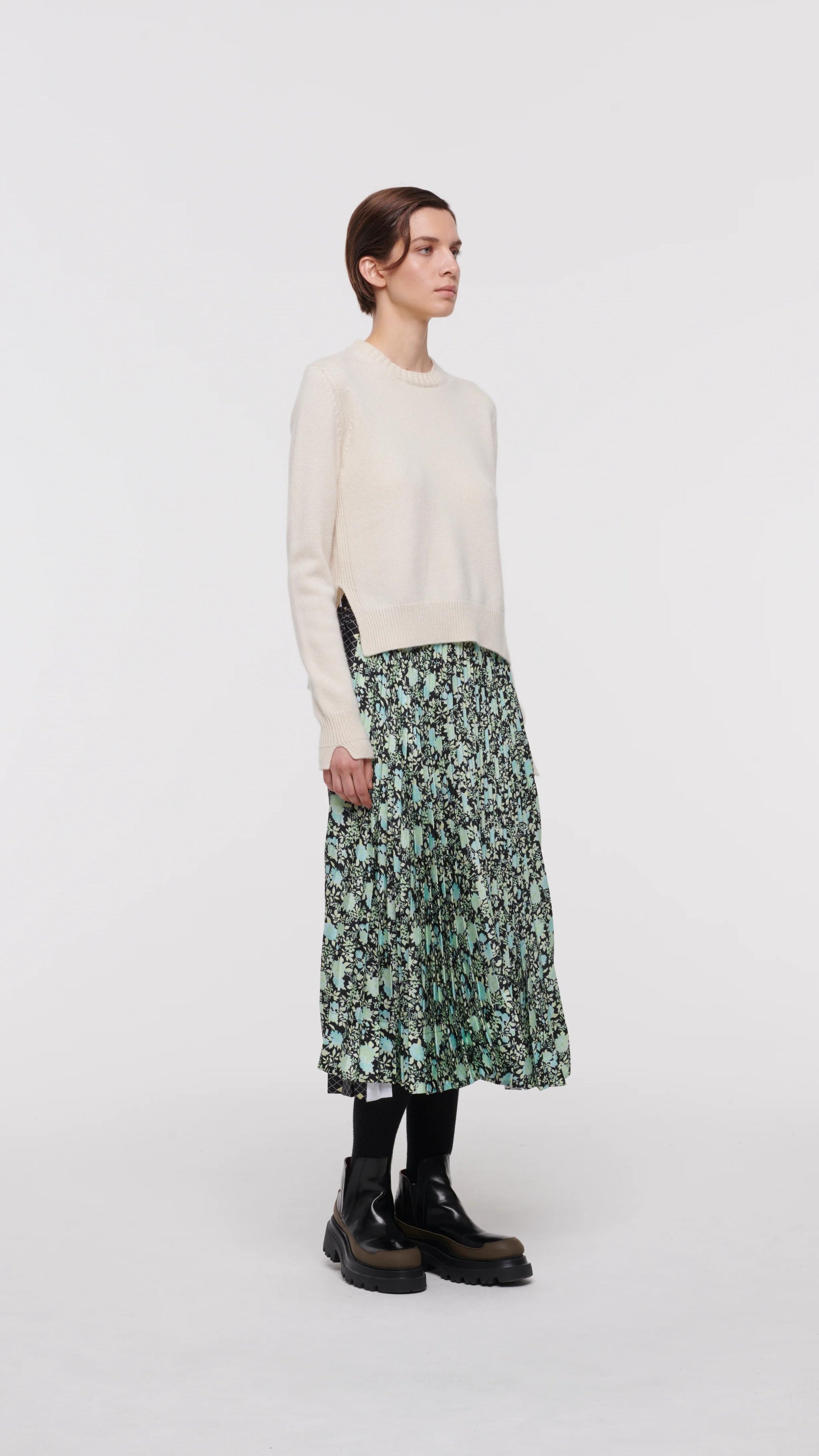 Plan C Pleated Midi Skirt in Backlit Dahlia Print.  Featuring alternating geometrical and flower prints, a slender pleated front, and larger pleating on the back, this skirt falls to a midi length asymmetric hem. The elasticated waist offers perfect comfort and easy fitting. Product photo shown from the front and side.