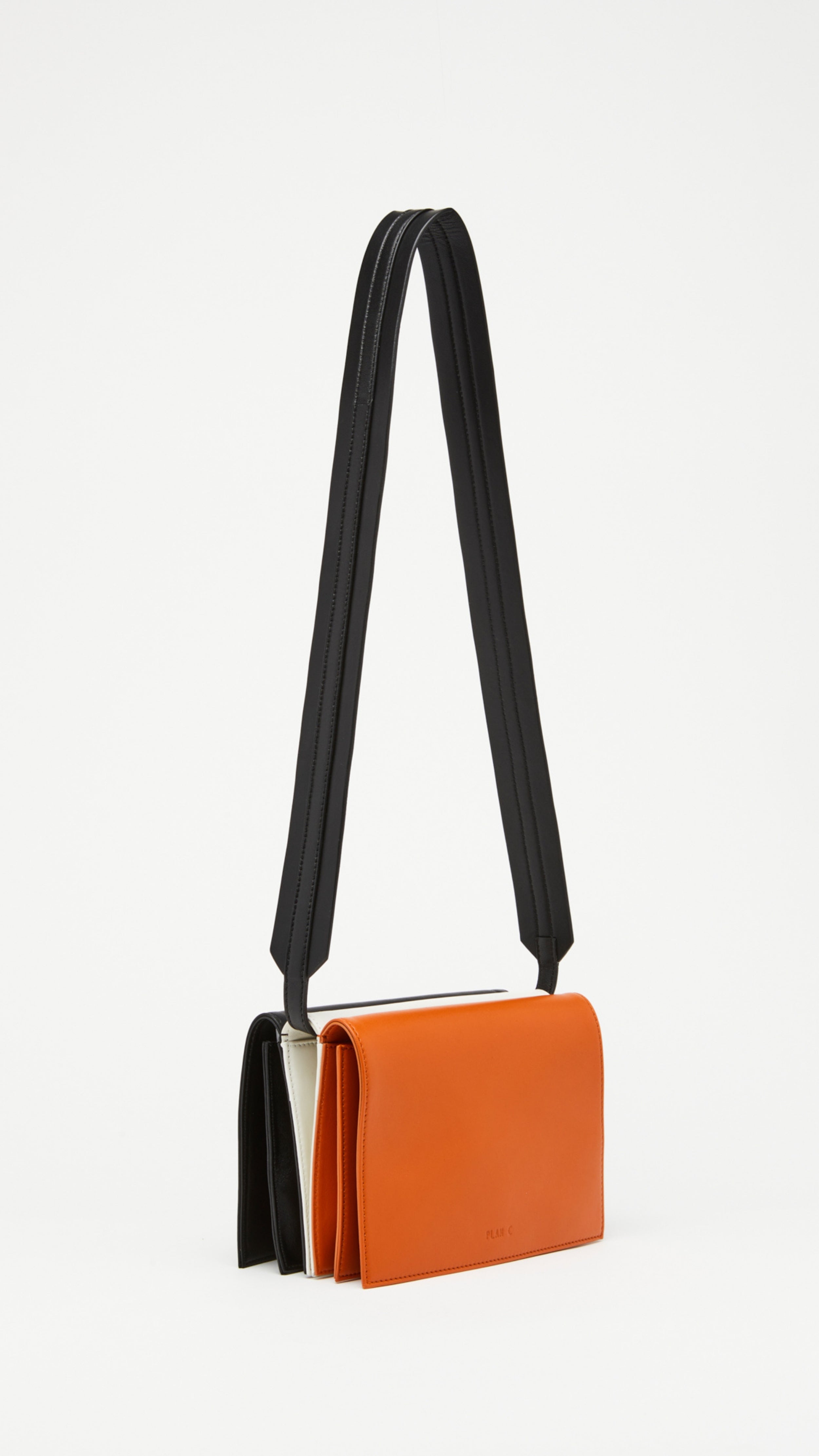 Plan C Tri Color Leather Crossbody Bag. Crafted from fine italian leather in black, white and camel. It has an adjustable black strap. Product shown from front side.