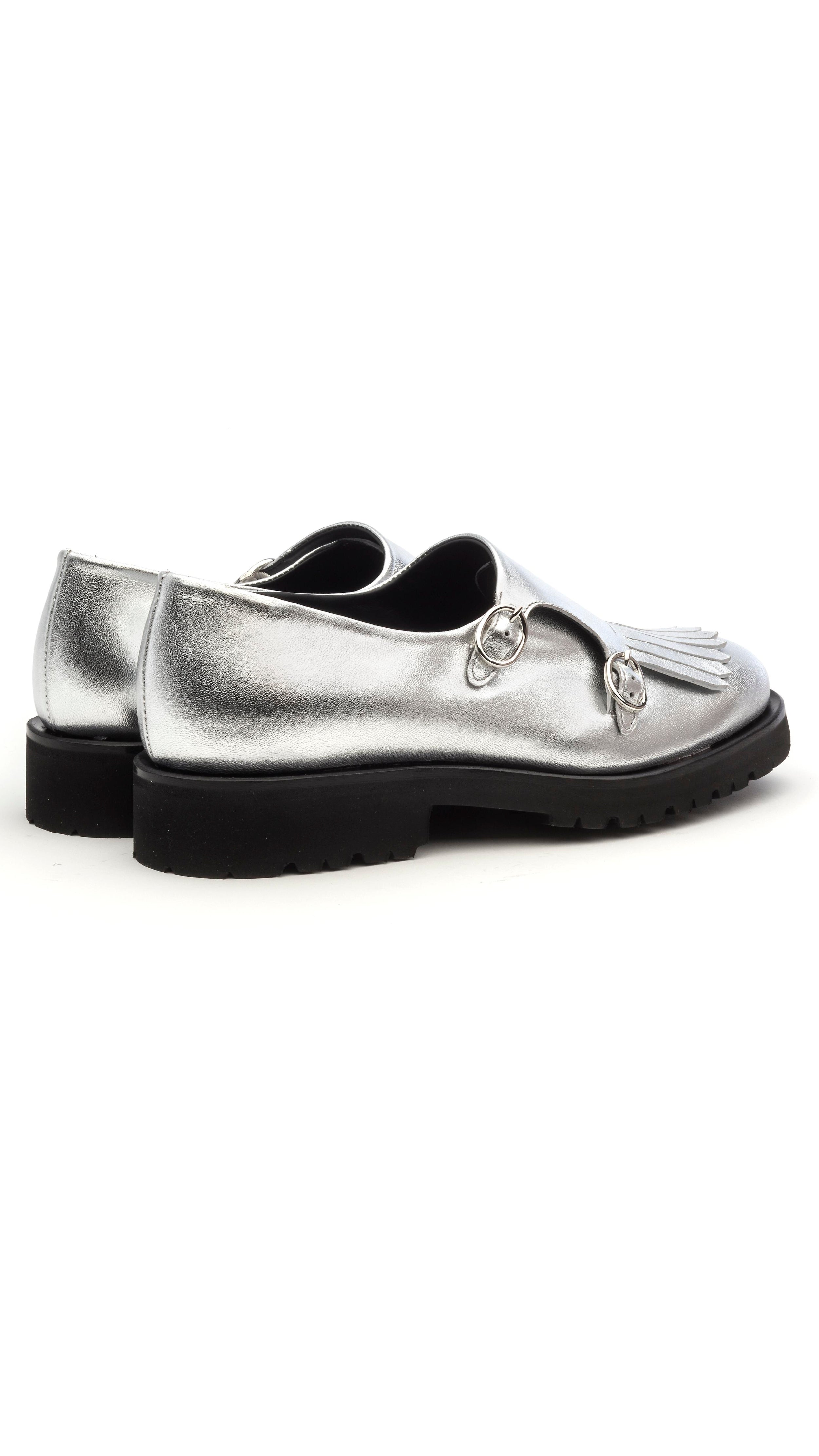 The Cedar Brogues are handcrafted in Italy with luxurious soft metallic silver calf skin. They have side buckles and fringing to the toe for a distinctive finish. The 10mm platform heel. Photo facing the back and side.