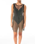 Leslie Amon Leslie Mini Net Dress in Black. Crafted from lightweight net material and encrusted with black rhinestones. Sleeveless and lands to mid knee length. Shown on the model facing front.