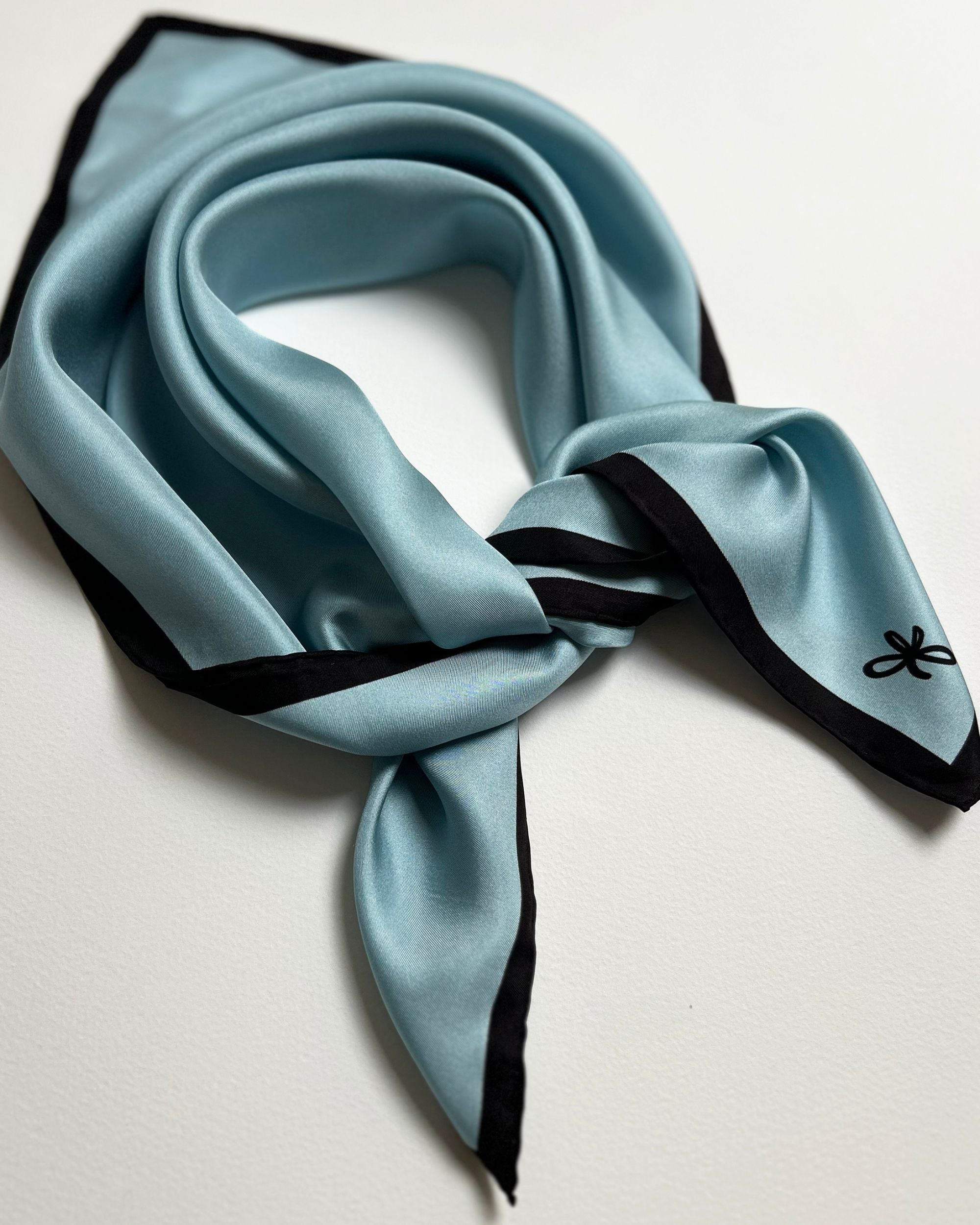 Light blue silk scarf tied in a knot
