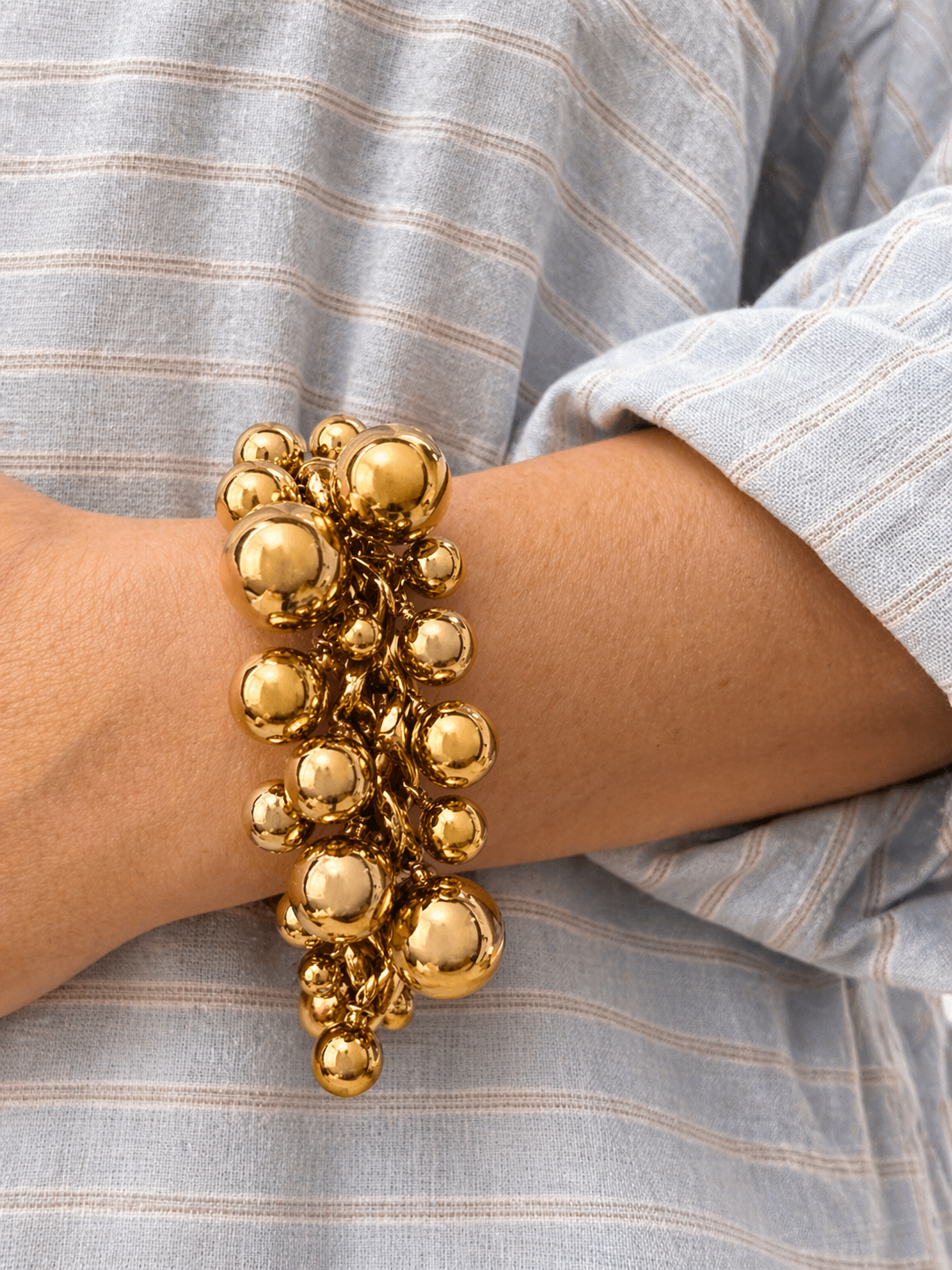 Françoise x Gas Bijoux Stellar gold bracelet worn on wrist, showing full volume of sphere cluster