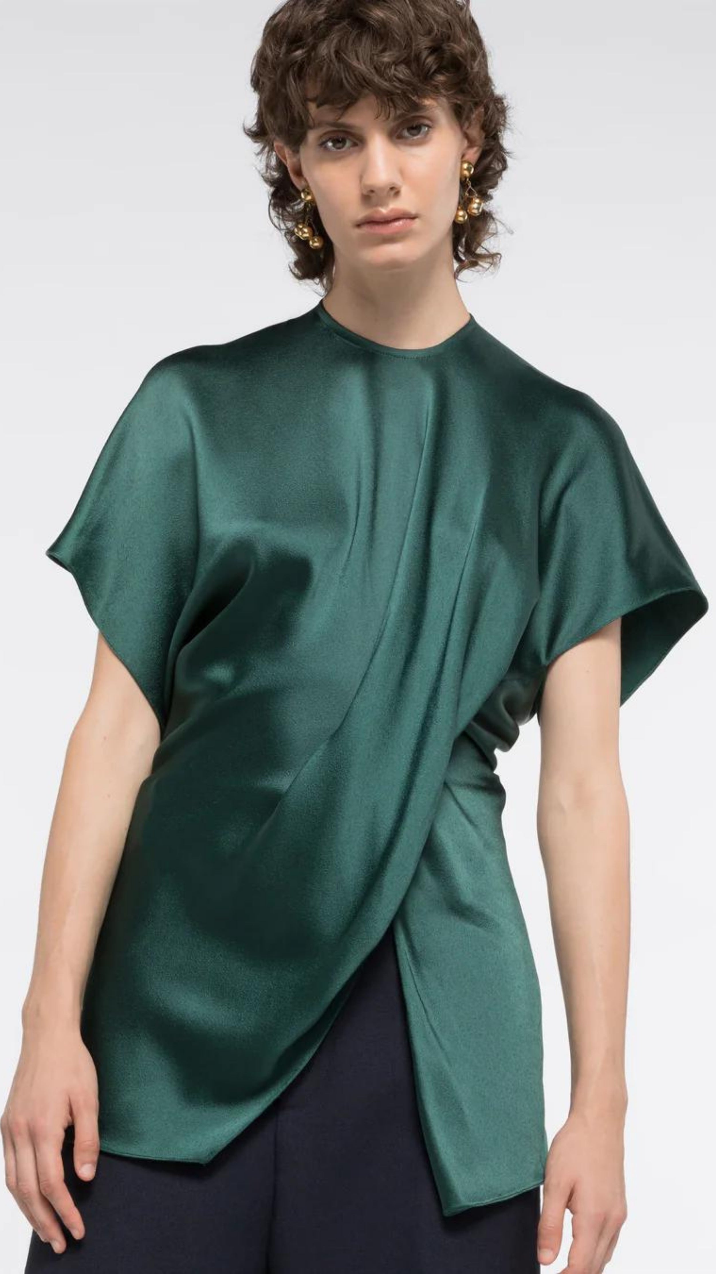 AZ Factory Colville Molly Molloy Lucinda Chambers, Asymmetric Satin Tee Shirt. Elegantly draped in forest green satin material in a classic tee shirt shape. Shown on model facing forward and close up.