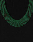 AZ Factory Colville Molly Molloy and Lucina Chambers Back Keyhole Asymmetrical Dress. Knit dress in black with a key hole cut out in the back. The neckline and the cuffs are rimmed in green and yellow. Asymmetrical long hem. Detail of knit fabric.