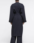 AZ Factory Colville Molly Molloy Lucinda Chambers, Draped Wool Coat in Navy. Wrap around wool coat made in Italy in navy blue. It has an ecru lining and can be worn open or belted for a more fitted style. Shown on model from the back.