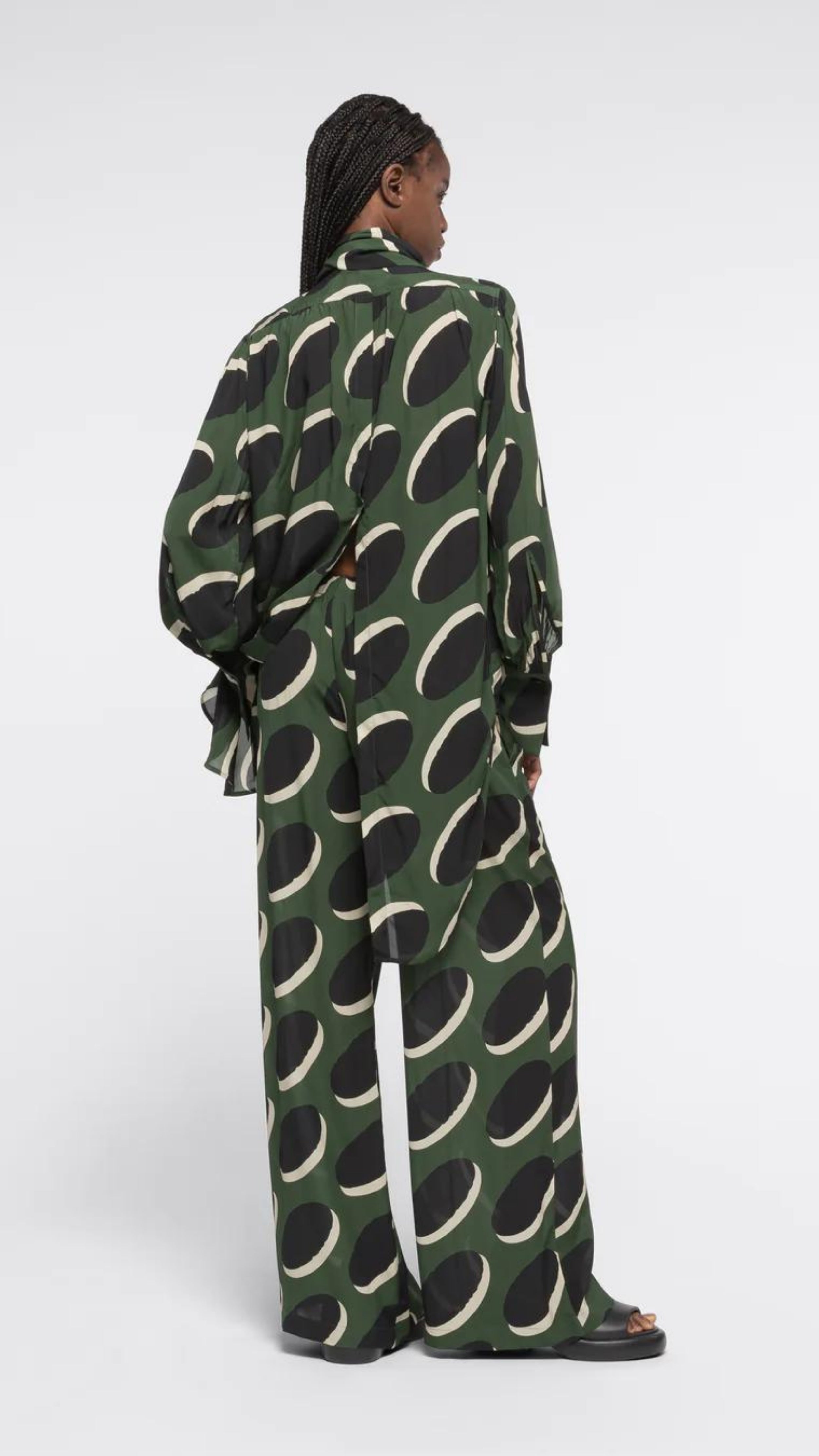AZ Factory Colville Molly Molloy Lucinda Chambers, Pajama Pants in Khaki Macaroon Pajama loose style silky pants with elastic and drawstring waist band. Crafted in olive green with black and ecru oval pattern. Shown on model facing back.