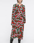 AZ Factory Colville Molly Molloy Lucinda Chambers, Printed Draped Midi Dress. Midi dress with long sleeves and a v cut neckline. It's a rust red with intertwining  rope pattern in green and sky blue. Shown on model facing front.