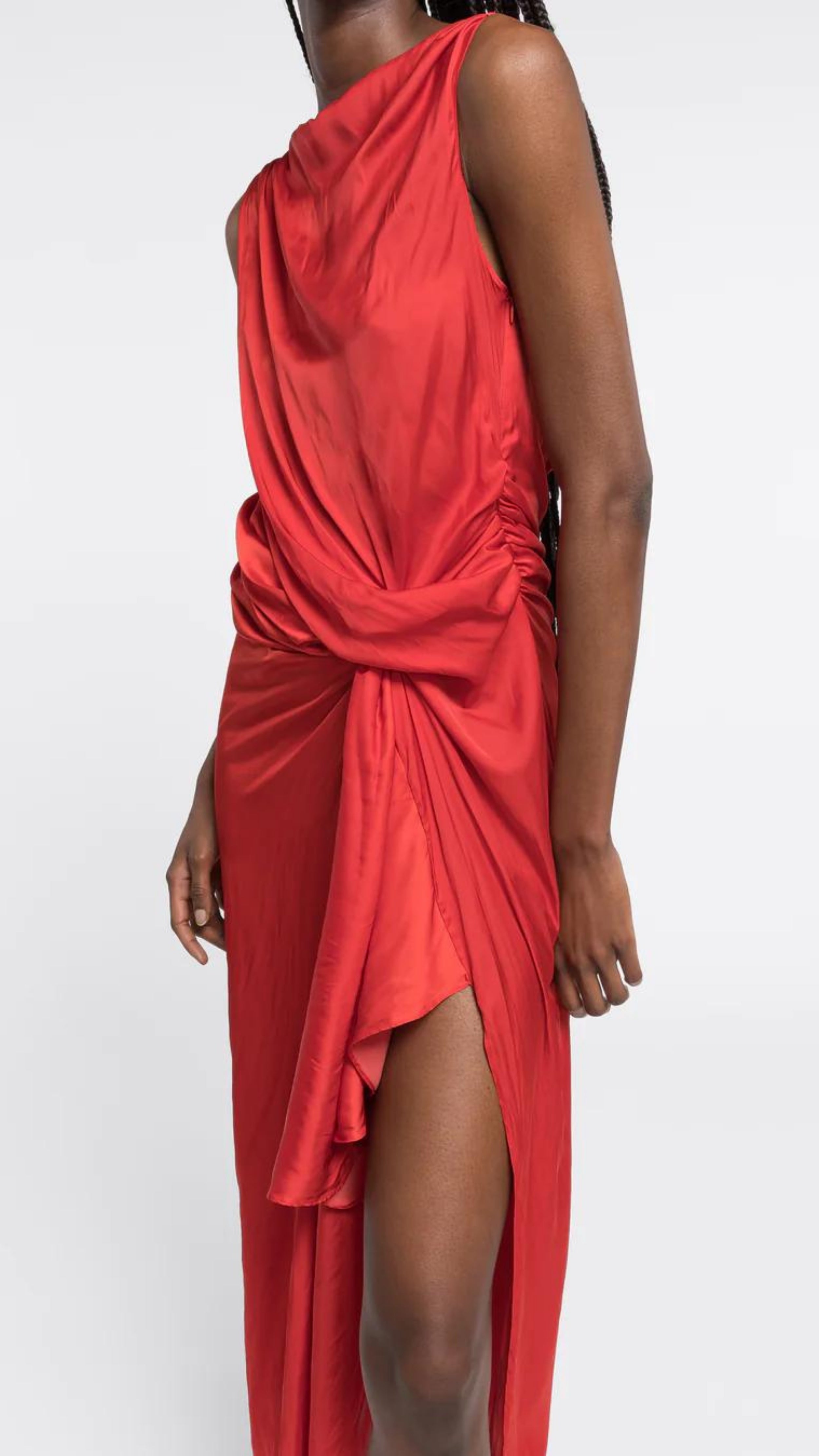 AZ Factory Colville Molly Molloy Lucinda Chambers, Sleeveless Draped Dress in Red An elegant red formal dress with a silhouette defined by a straight neckline and asymmetrical hemline. The waistline has detailed draping and the front leg as a slit. Shown on model with side draping detail
