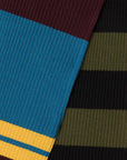 Colville AZ Factory Molly Molloy Lucinda Chambers, Color Block Striped Scarf. Extra long thin scarf with varying stripes in blue, burgundy, yellow, black, and olive green. Photo showing detail of knit fabric,.