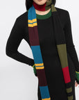 Colville AZ Factory Molly Molloy Lucinda Chambers, Color Block Striped Scarf. Extra long thin scarf with varying stripes in blue, burgundy, yellow, black, and olive green. Photo showing product on model.