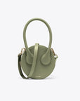 AZ Factory Round Cake Bag in Light Khaki Handcrafted in Italy with sustainable overstock leather, this bag features our AZ Amigo face design, a single extended top handle, and an attachable and adjustable leather cross-body strap. Complete with a zip closure and back pocket. Front view.