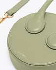AZ Factory Round Cake Bag in Light Khaki Handcrafted in Italy with sustainable overstock leather, this bag features our AZ Amigo face design, a single extended top handle, and an attachable and adjustable leather cross-body strap. Complete with a zip closure and back pocket, close up