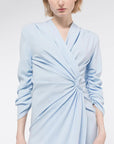 AZ Factory Lutz Huelle, Ella Dress. Crafted with a crepe texture in sky blue hue. V neck and draped, off center gathered front. Half length ruched sleeves  with a midi length skirt. Shown on model facing front, detail.