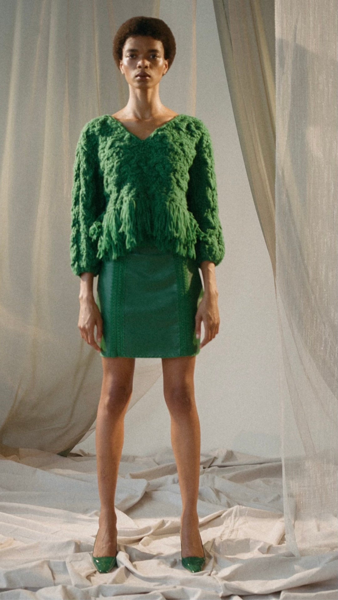 Alejandra Alonso Rojas Leather Mini Skirt with Crochet Seams. Crafted in super soft lamb leather with front and back silk crochet seams in a kelly green. The skirt is shown on the model facing forward.