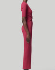 Altruzarra, Argolis Dress. Rose pink colored ribbed knit dress. Body hugging with flattering, slimming from waist detail. It has a rounded collar, half short sleeves and midid length. There are two side slits to the knee. Shown on model facing side. Available at experience 27 in madrid spain.