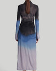 Altuzarra Claudia Dress in Eventide Made from jersey fabric, it is a slim-fitting midi dress featuring ruched detail at the waist, shirt dress buttons up the front, and side slits at the hem. The color is an ombre of deep grey, blue, and pale grey. Shown on model facing back.