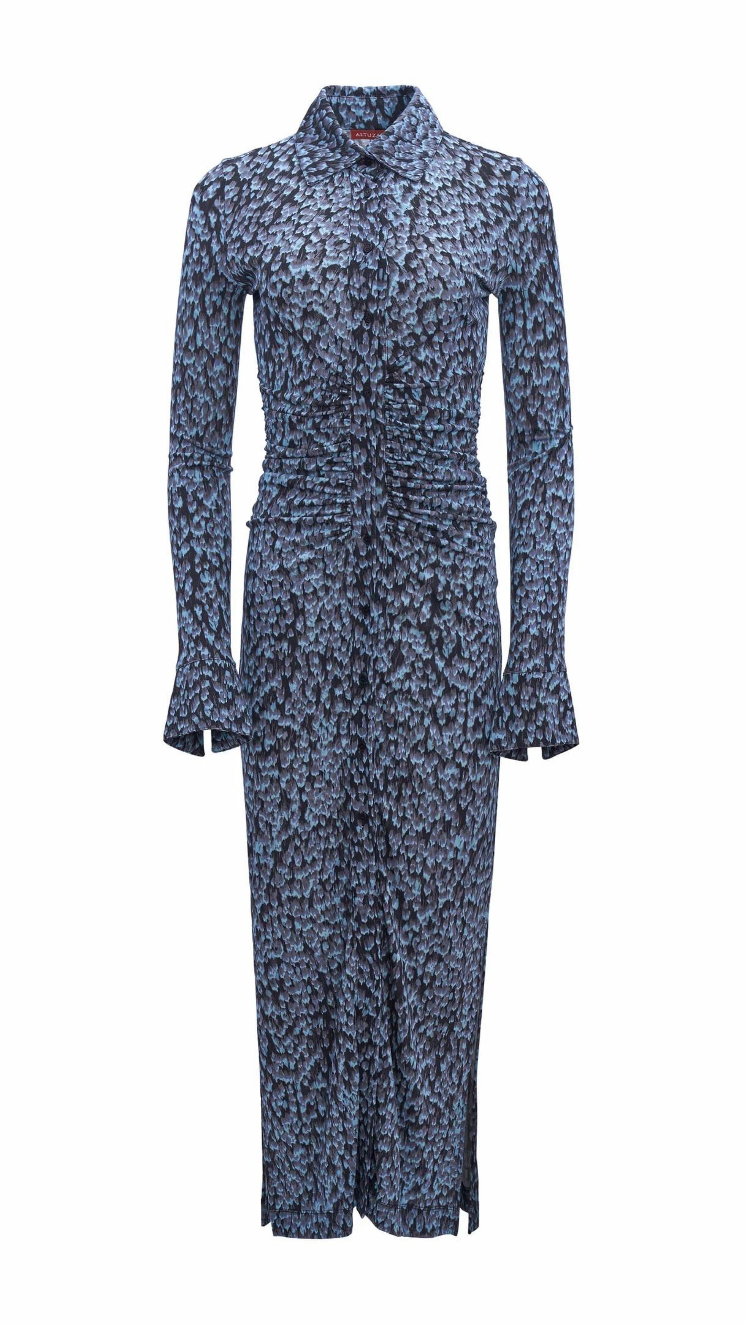 Altuzarra Claudia Dress in Murex Feather Print. Made from the softest jersey material in the Murex Feather print of various blue tones. This dress buttons up the front, has long sleeves and a shad collar. Ruching at the waist provides an incredible fit. Product photo facing front.