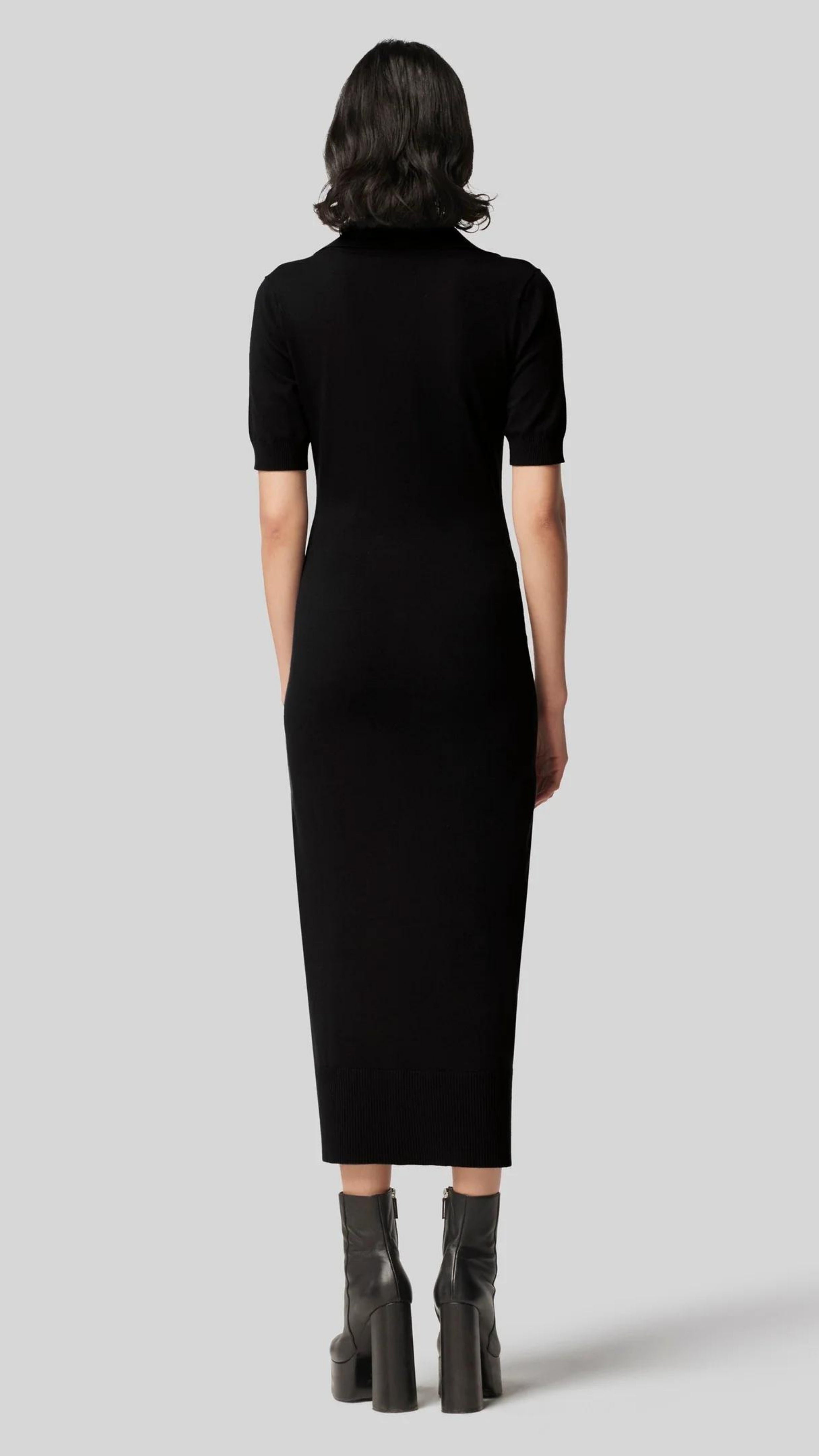 Altruzarra Hestia Dress in Black. A lightweight, super soft knit dress. Body fitting with gold buttons from front top to bottom. Midi length, shirt collar and half short sleeves. Black. Shown on model from back view. Available at experience 27 in Madrid Spain.