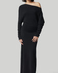 Altuzarra Black Cashmere Kasos Dress. The dress features an oversized off-the-shoulder top, slim long sleeves, an ankle-length skirt with a side slit hem. Off duty ballerina elegance in the style. Photo shows model wearing the dress facing front.