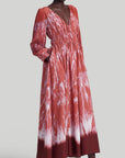 Altuzarra Kathleen Dress The Kathleen Dress is a statement dress using Altuzarra's renowned Shibori dyeing technique in shades of red, cranberry and orange. It has a maxi silhouette, a V-neckline, a ruched waist, long pleated sleeves, and button-fastening cuffs. Shown on model facing front and side.