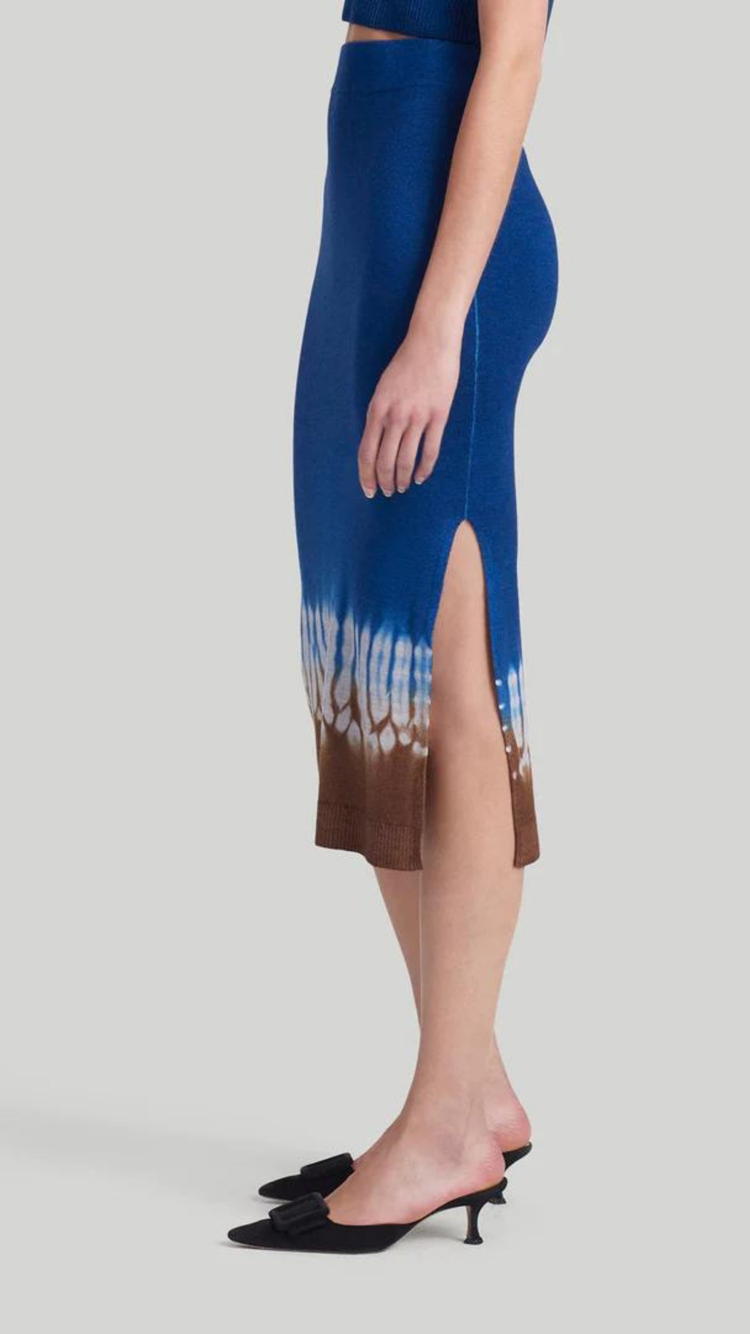 Altuzarra &#39;Morse&#39; skirt, featuring Altuzarra&#39;s iconic Shibori tie-dye technique in brown, white, and blue. Made from 100% Superfine Merino 130&#39;s wool, this high-rise pencil silhouette midi length skirt. Shown on model facing side.