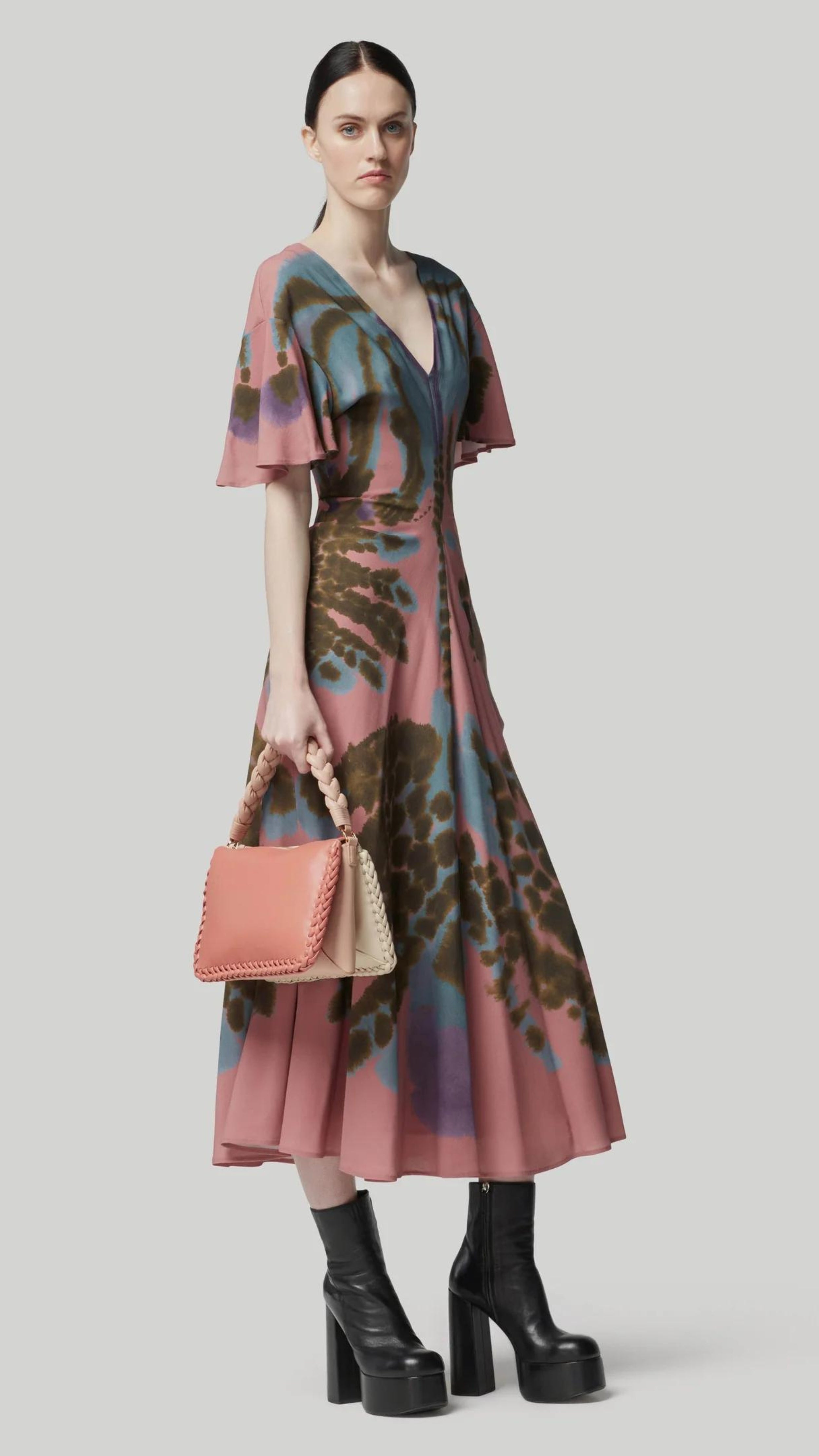 Altuzarra Pelopenese Dress. Rose pink, sky blue and green rorschach pattern midi dress. With a v neckline and soft draping half sleeves. Flowing skirt with waist line rouching. Shown on model facing front and to the sid