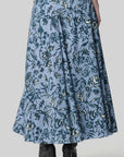 Altuzarra Pythia Skirt in Amsonia Shibori Flower. A midi length, aline style skirt with beautiful twist detail at the waist. Crafted in 100% cotton with a natural ecru color floral print over a light blue background. Shown on model facing back. Available at experience 27 in Madrid spain.