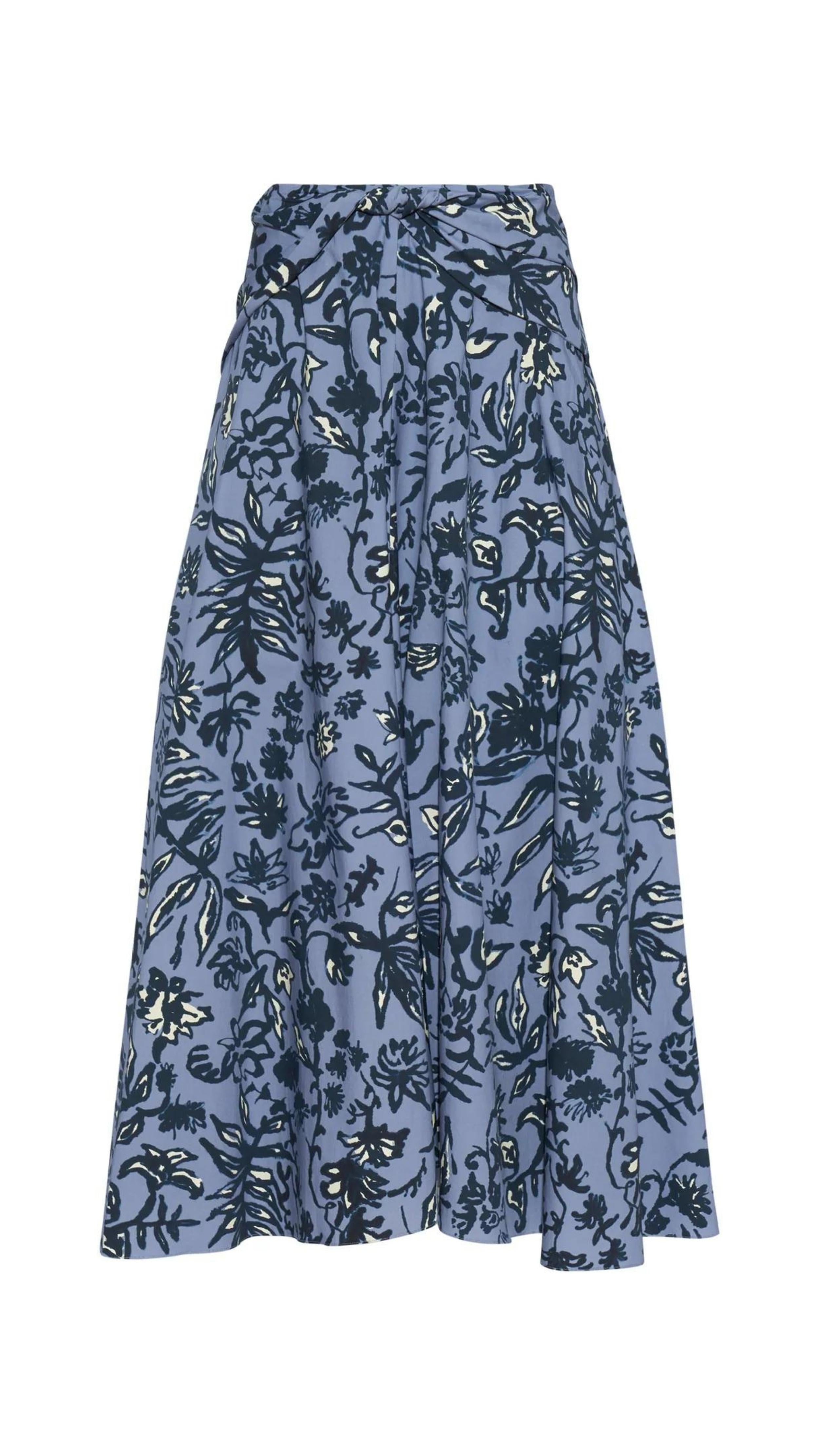 Altuzarra Pythia Skirt in Amsonia Shibori Flower. A midi length, aline style skirt with beautiful twist detail at the waist. Crafted in 100% cotton with a natural ecru color floral print over a light blue background. Shown facing front. Available at experience 27 in Madrid spain.