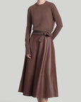 Altuzarra Varda Skirt Made from soft, subtle brown lamb leather, it has an A-line skirt. Midi-length SS24 runway piece. The skirt hem falls to just below the knee. Shown on model facing front.