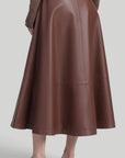 Altuzarra Varda Skirt Made from soft, subtle brown lamb leather, it has an A-line skirt. Midi-length SS24 runway piece. The skirt hem falls to just below the knee. Shown on model facing back.