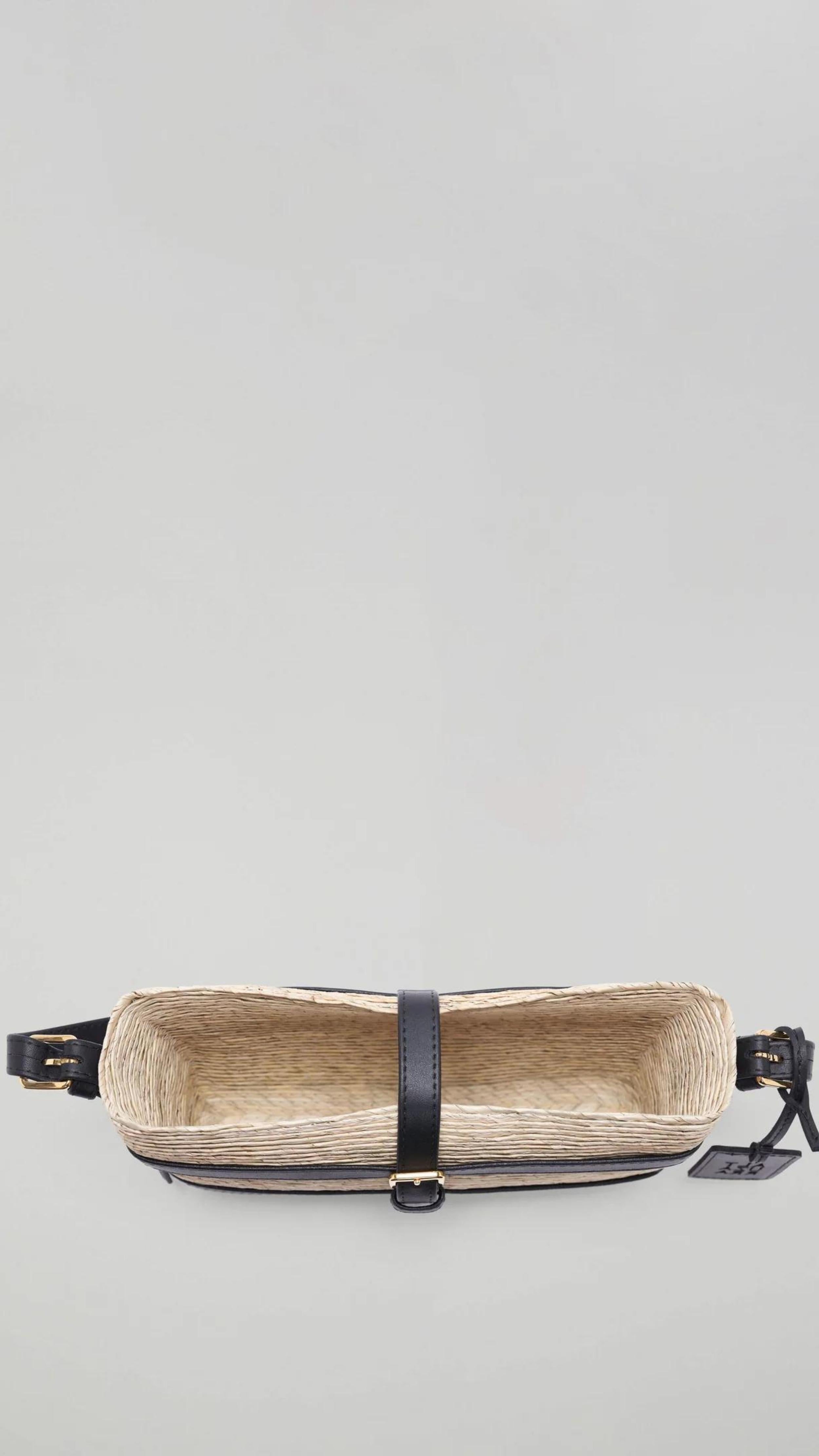 Altuzarra Watermill Shoulder Bag in Natural and Black. Summer raffia clutch with adjustable leather straps. Natural raffia color with black leather detailing and gold hardware. This is a summer purse. Shown from top view. Available with Experience 27 in Madrid Spain