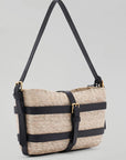 Altuzarra Watermill Shoulder Bag in Natural and Black. Summer raffia clutch with adjustable leather straps. Natural raffia color with black leather detailing and gold hardware. This is a summer purse. Shown facing front view. Available with Experience 27 in Madrid Spain