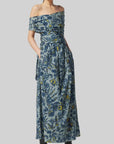 Altuzarra Corfu Dress in Stormcloud Shibori Flower. Relaxed off the shoulder cotton dress in beautiful grey blue, dark blue and yellow floral pattern. Wrap around style top with wrap around belt flows into the straight midi length skirt. Shown on model facing front. Available at experience 27 in madrid spain.
