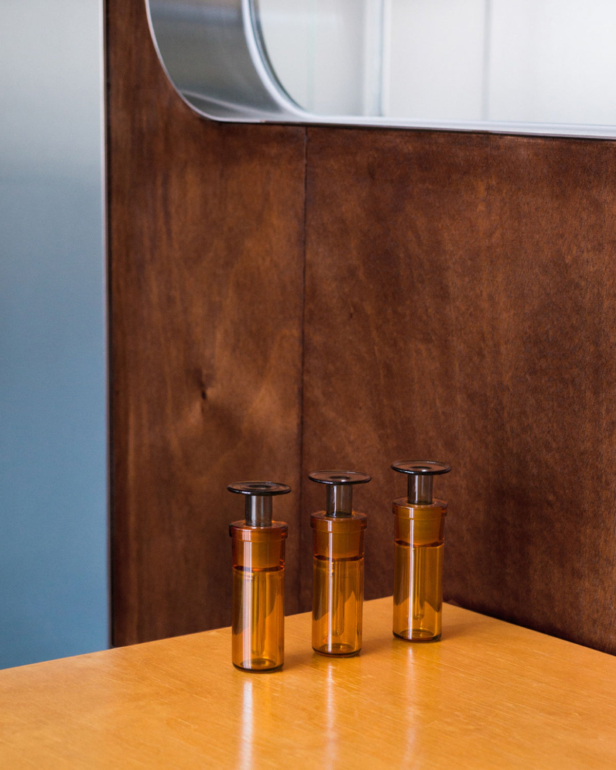 ARPA fragrance bottles displayed on an amber plinth against a copper-toned interior