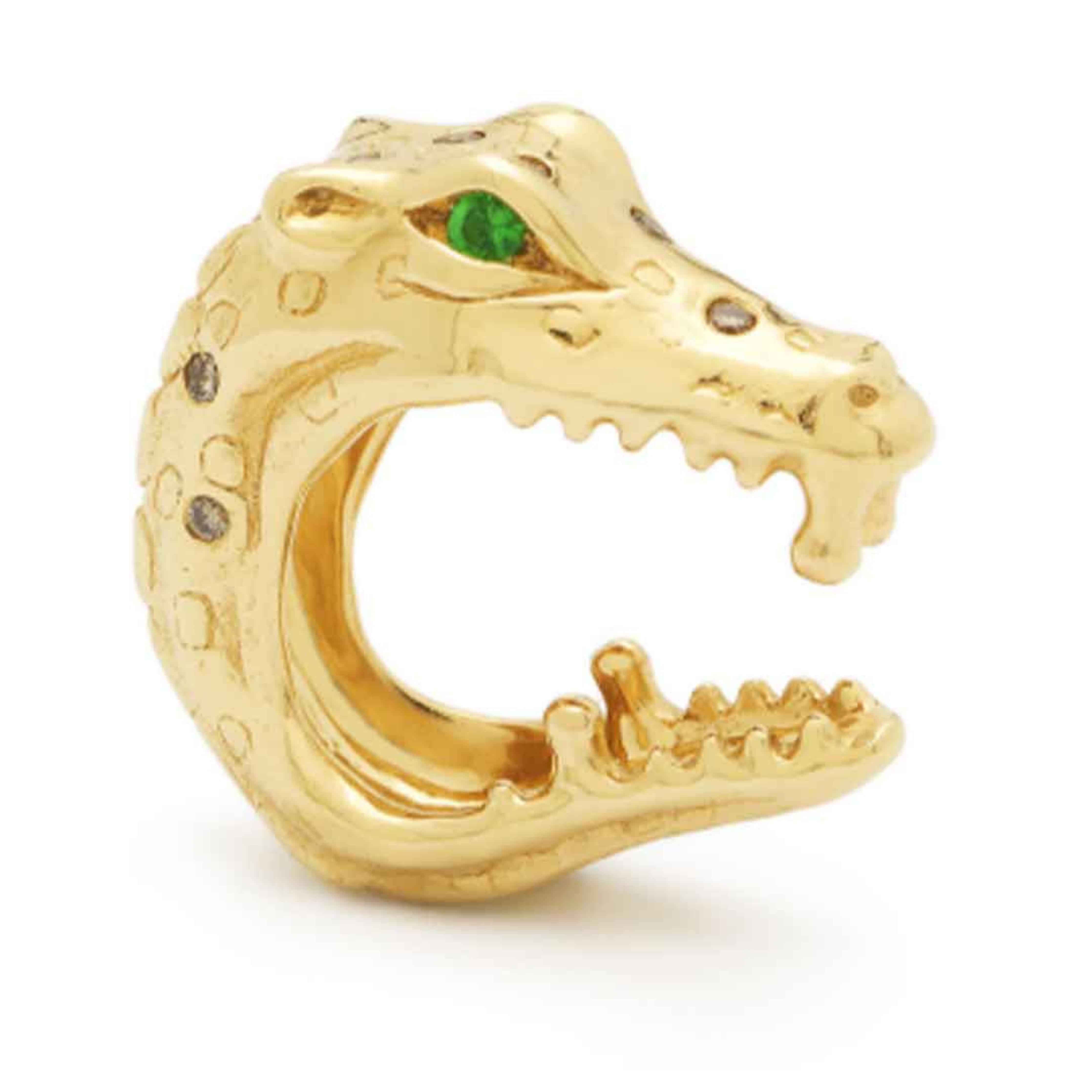 Bibi van der Velden Alligator Bite Earhugger. An ear cuff in the shape of a biting alligator. Made from 18K gold and emerald eyes with diamond accents. Photo shows ear cuff from the side view.