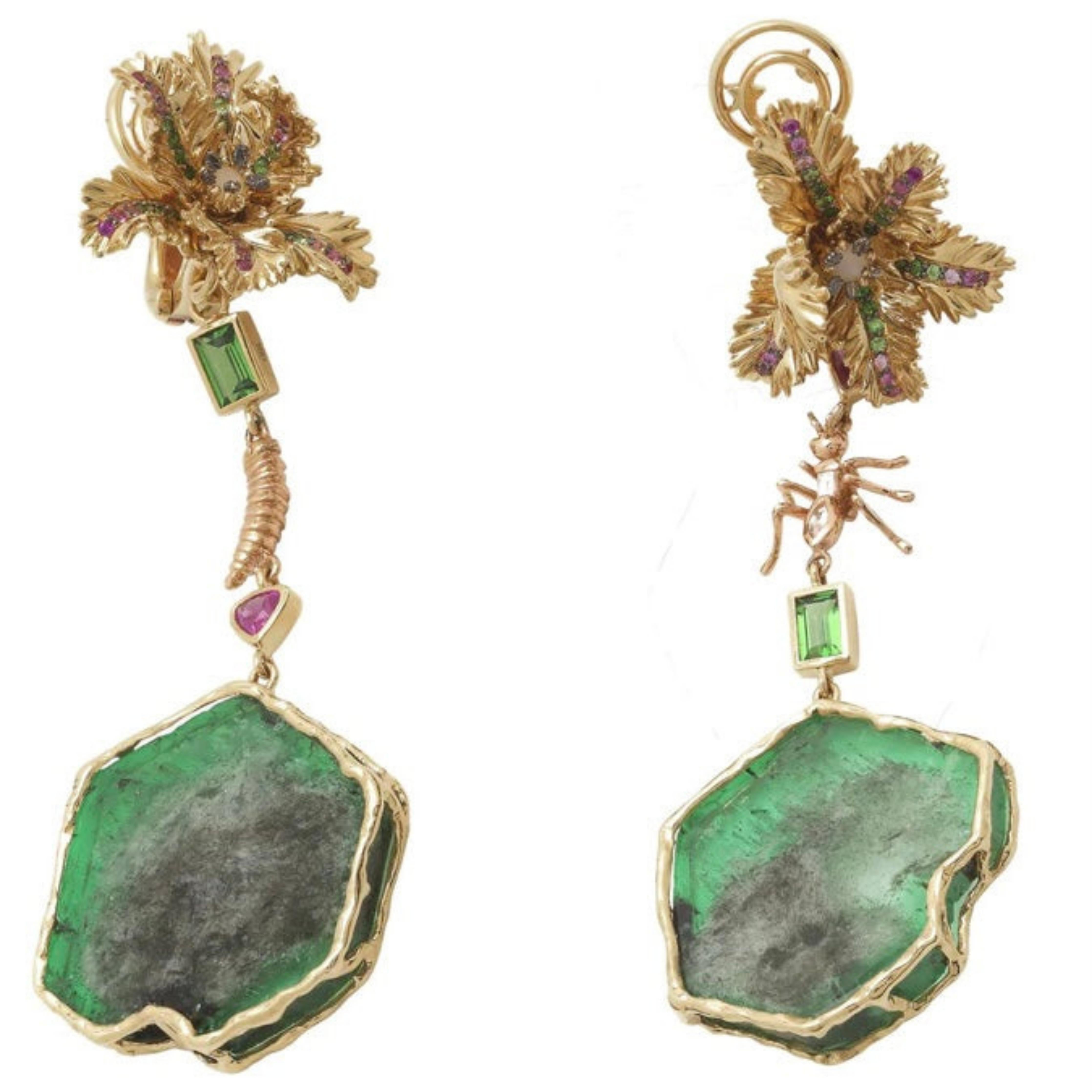 Bibi van der Velden Emerald Slice Earrings One-of-a-kind raw emerald slices set in 18K Yellow Gold flower studs set with pink sapphires, green tsavorites and an opal at the center. Each earring reveals unique details - one with a gold and diamond ant and the other with a rose gold maggot. The emerald slices can be removed to wear just the studs. Shown from the front view.